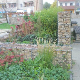 Stone-filled wire baskets used as landscaping elements in a garden