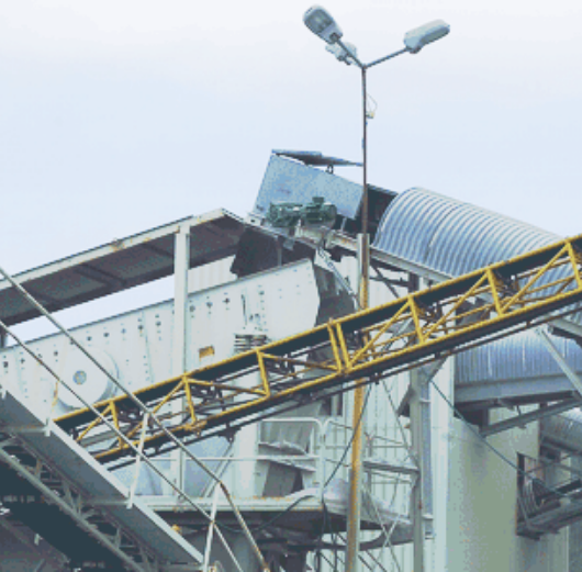 Conveyor belt transporting crushed material and dumping stones onto a rock pile