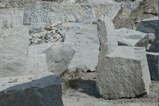 Large broken granite blocks stacked in a quarry
